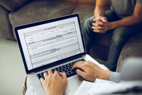 Men sitting on a couch fill out a cyber insurance application