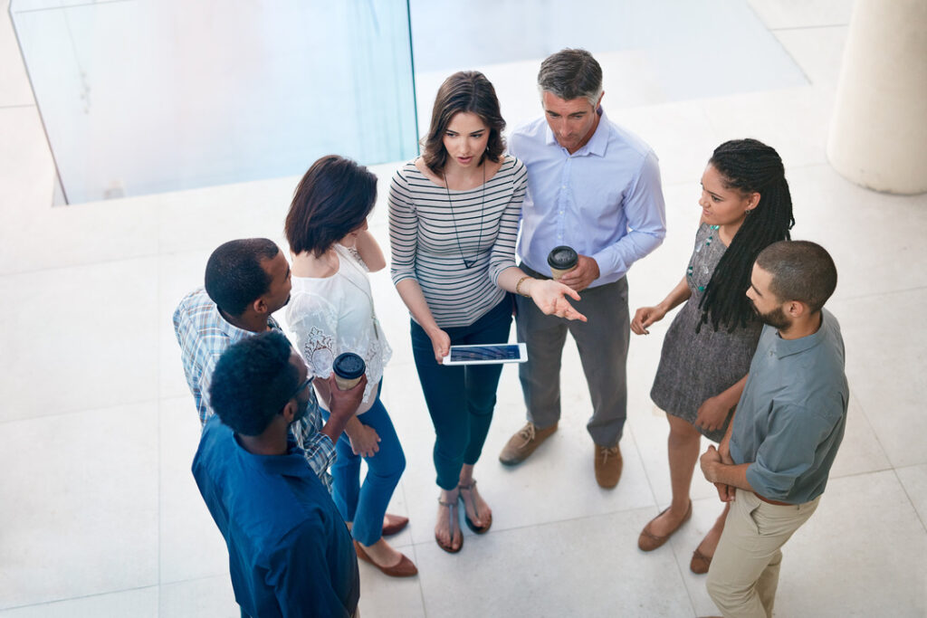 A group of coworkers gathers in the hall to discuss incident management