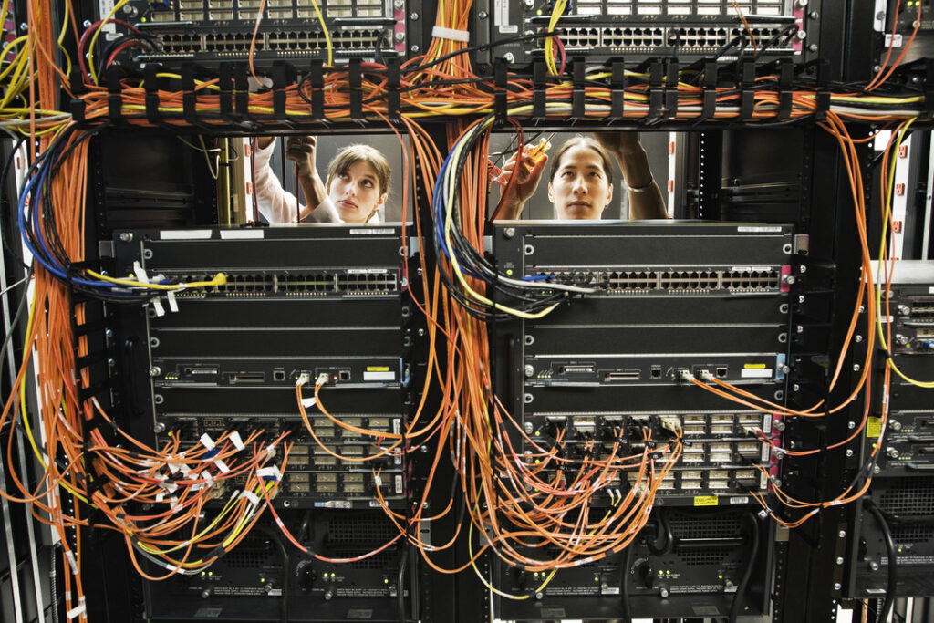 Two IT professionals work with cabling to set up network segmentation