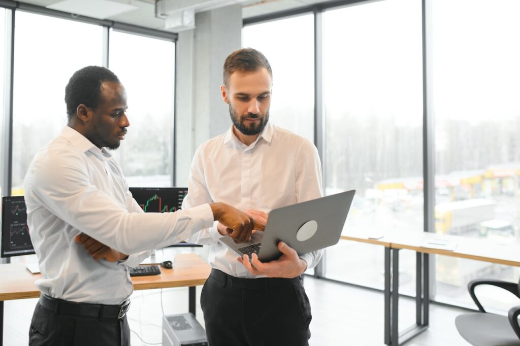 employees looking at laptop discussing zero trust implementation