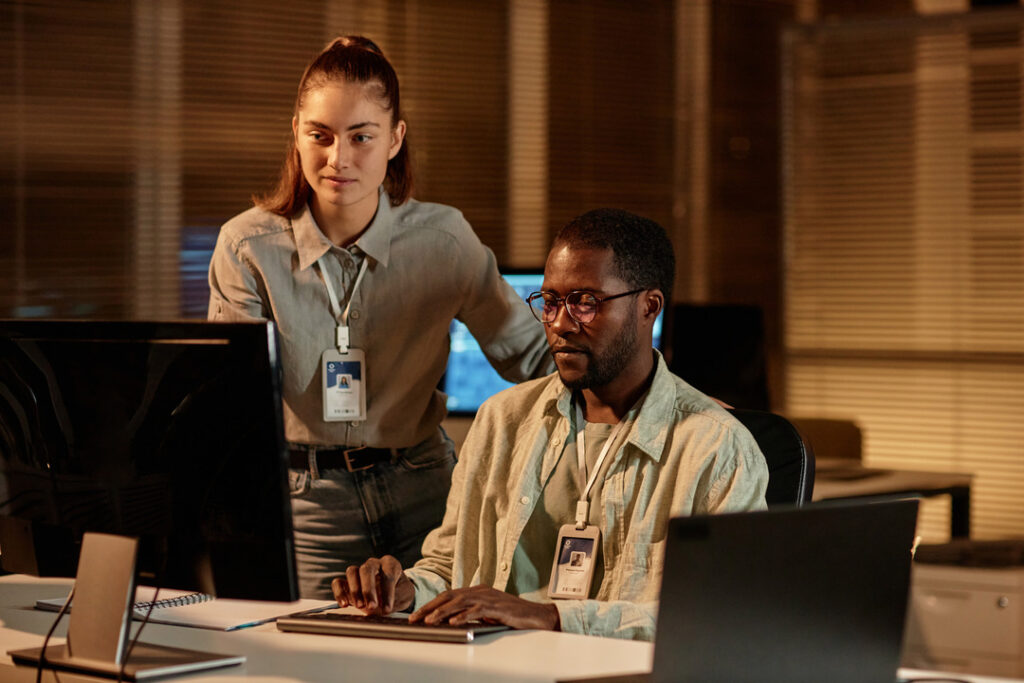 Two IT techs look at a computer screen